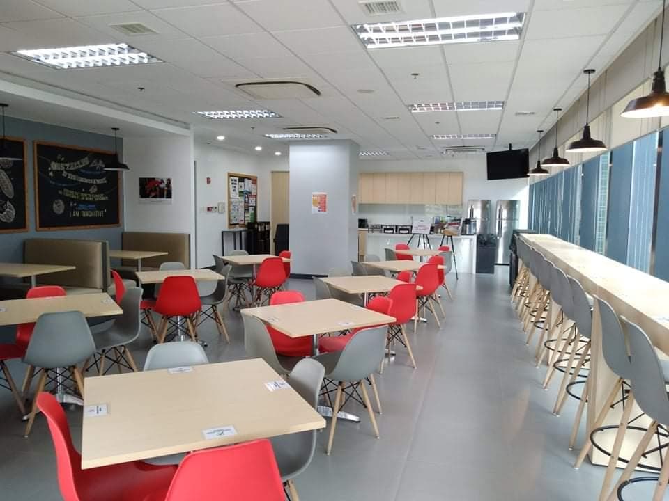 Bright pantry and breakout area with red and grey chairs