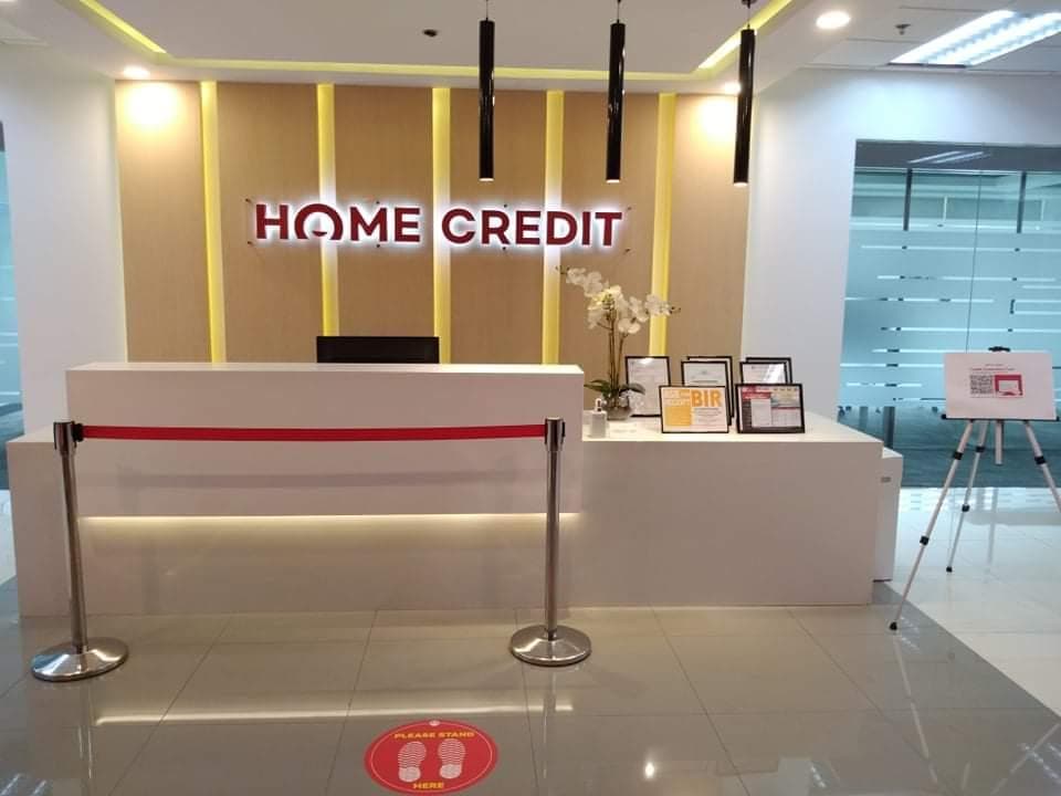 Home Credit office reception with a lit logo wall