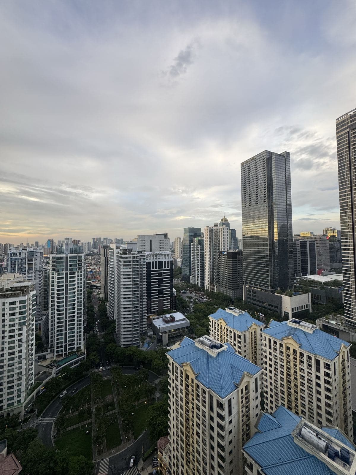 Glass towers and tree-lined streets of BGC in daylight