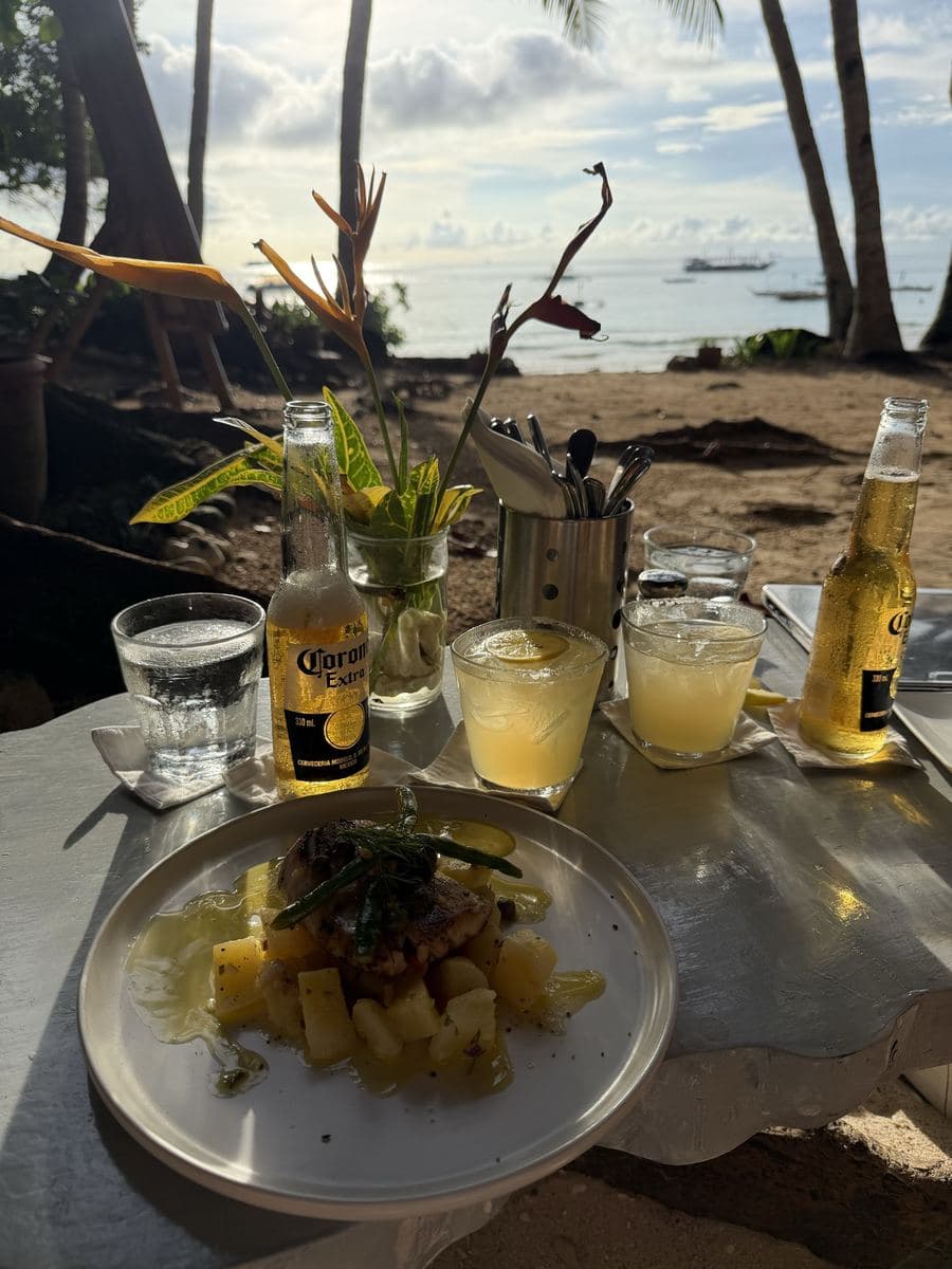 Lunch and cold drinks on a table at a beachfront restaurant