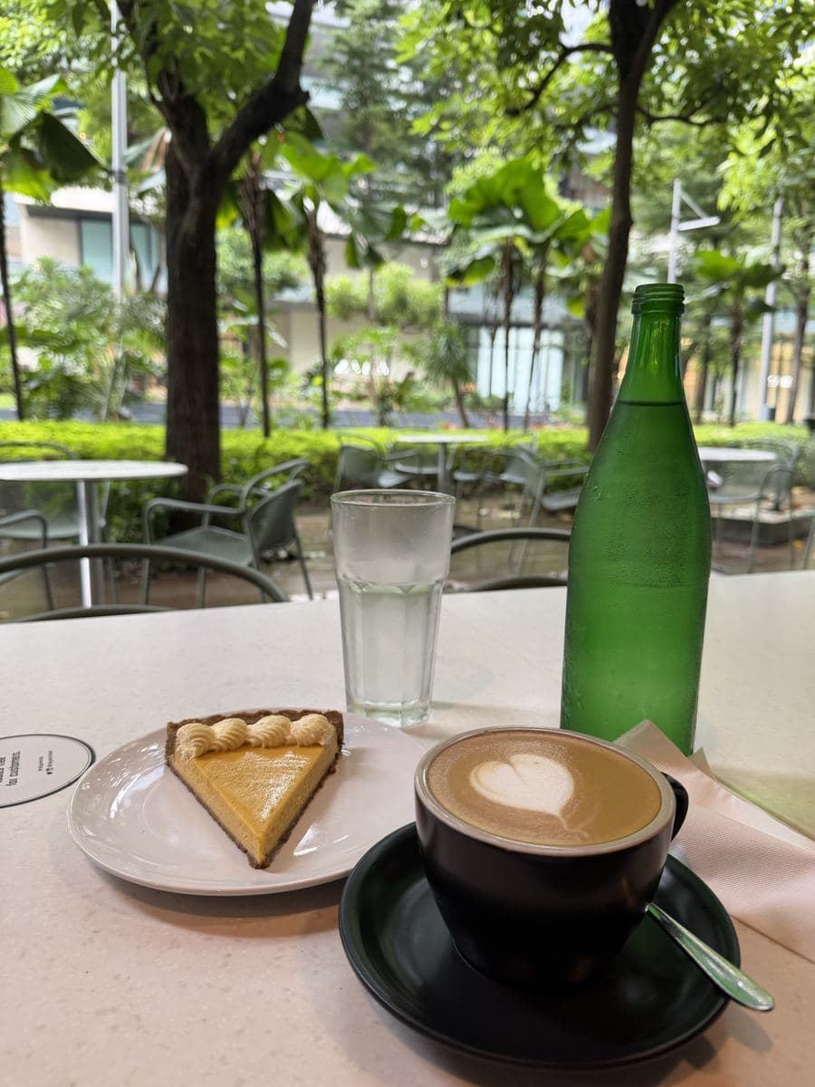 A heart-shaped latte and a slice of pie at a café in a green BGC garden