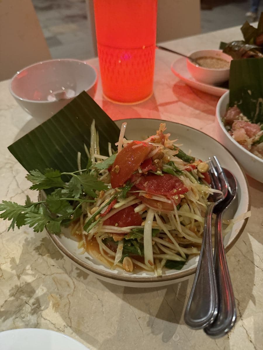 A fresh green papaya salad served on a banana leaf