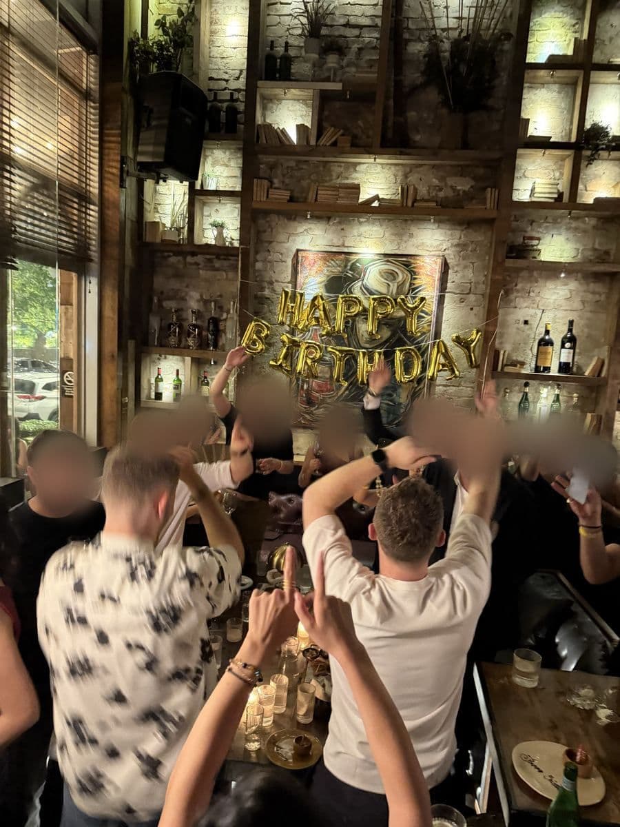 Friends cheering at a birthday dinner in a restaurant